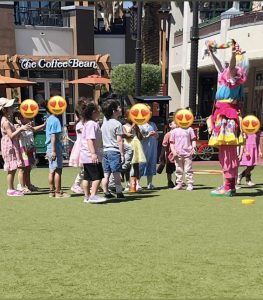 Emily Lauren Lepine as Miss Fairy G performs for a large group of smiling kids at Town Square Las Vegas.