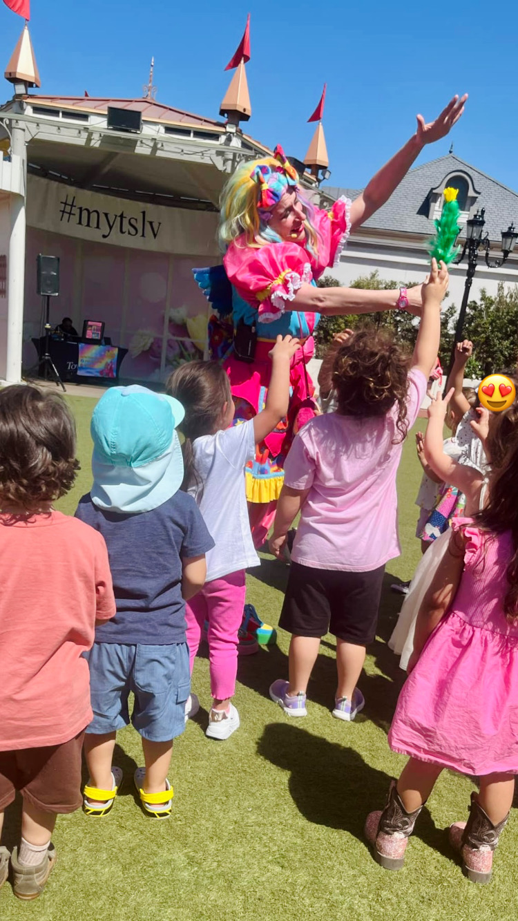Miss Fairy G surrounded by children enjoying a magical moment